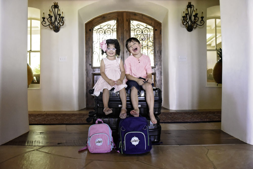 kids ready to go on a trip with luggage