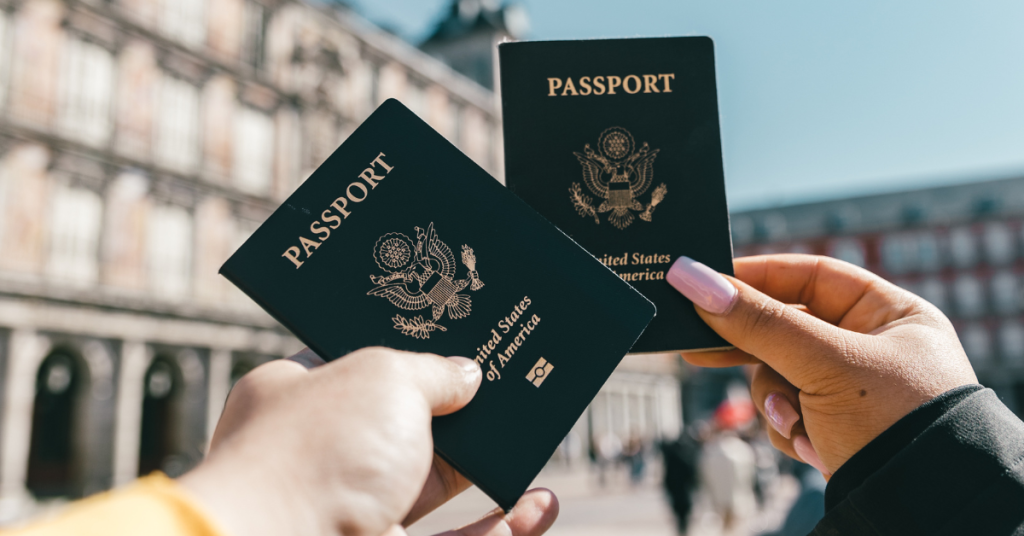 two people holding out passports