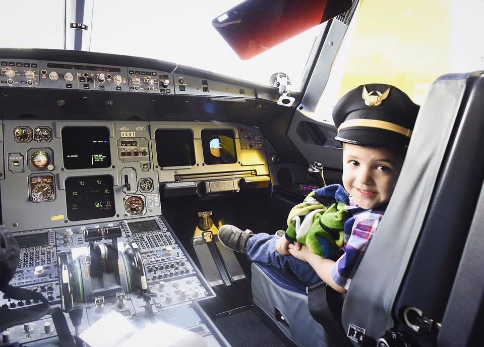 kids sitting on airline cockpit